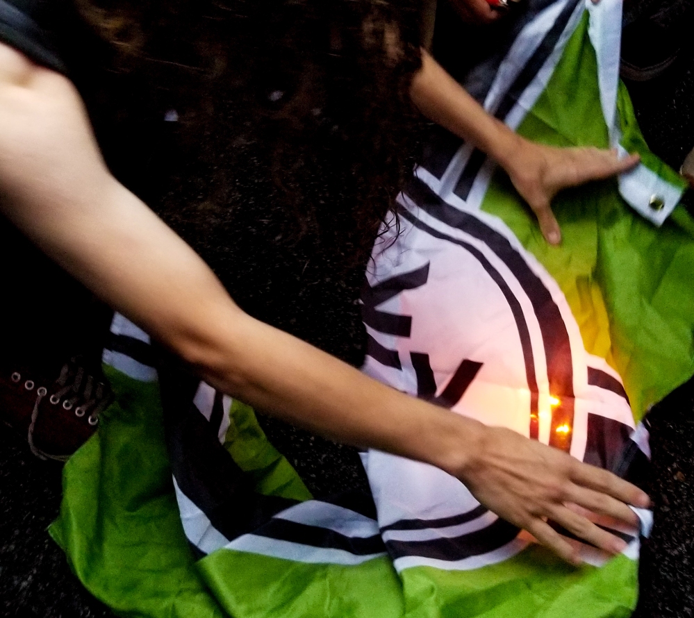 Protesters light the racist Kekistan flag on fire. (Photo by Adam Schrader)